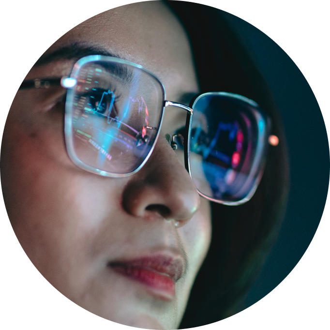 a woman looking at a computer screen with it reflected in her glasses